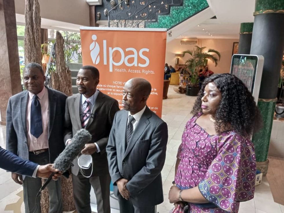 General Secretary of Ministry of Health (MOH) speaking to interviewer, standing alongside MOH colleagues.